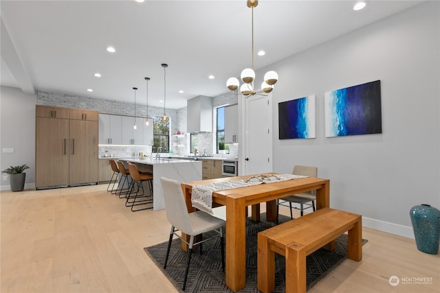 dining room with light hardwood / wood-style floors and a chandelier