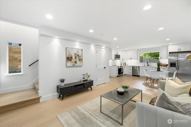 living room featuring sink and light hardwood / wood-style floors