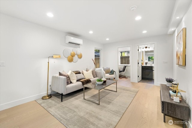 living room with a wall mounted AC and light hardwood / wood-style floors