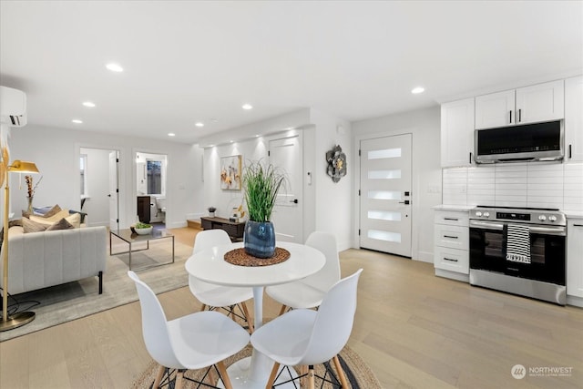 dining space featuring light hardwood / wood-style floors and a wall mounted AC