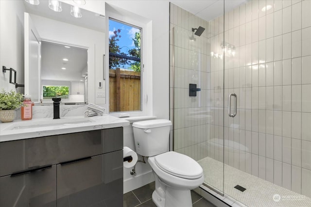 bathroom with toilet, vanity, tile patterned floors, and a shower with shower door