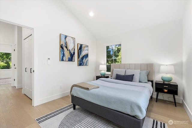 bedroom featuring high vaulted ceiling and light wood-type flooring