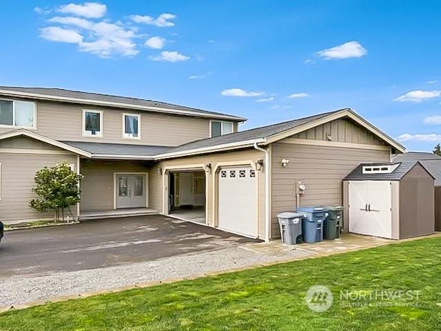 back of house with a garage and a yard