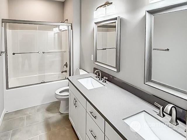 full bathroom with vanity, tile patterned flooring, bath / shower combo with glass door, and toilet