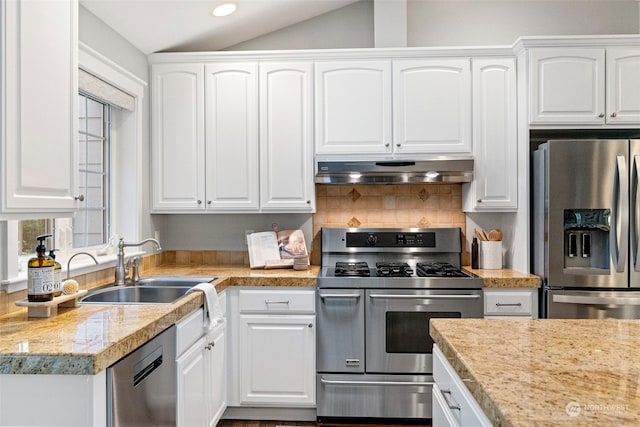 kitchen with sink, stainless steel appliances, vaulted ceiling, and white cabinets