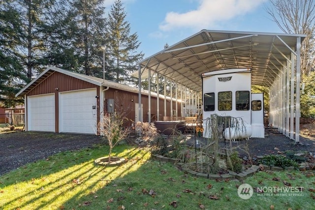 exterior space featuring a carport, a garage, an outdoor structure, and a yard