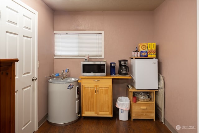 interior space with water heater and dark hardwood / wood-style flooring