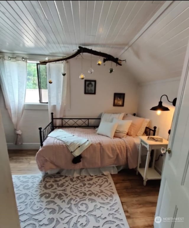 bedroom featuring wood-type flooring, vaulted ceiling, and wooden ceiling