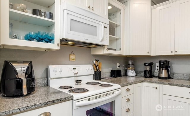 kitchen featuring white cabinetry, light stone counters, and white appliances