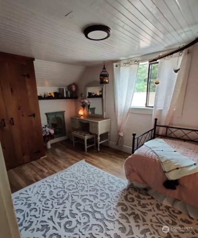 bedroom with wood ceiling and light hardwood / wood-style floors