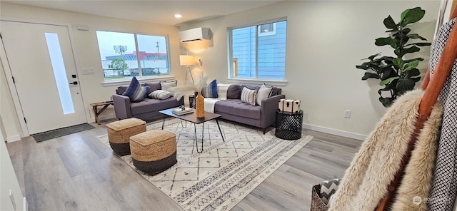 living room with light wood-type flooring and an AC wall unit