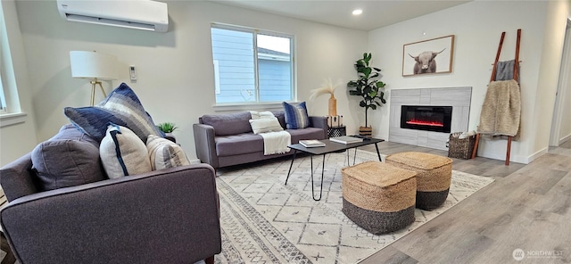 living room featuring light hardwood / wood-style floors and an AC wall unit