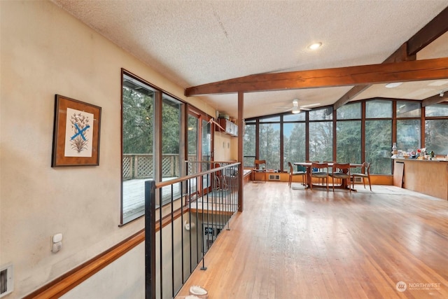 sunroom / solarium featuring vaulted ceiling with beams