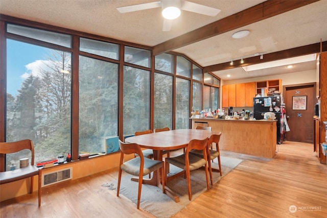 sunroom / solarium with beamed ceiling and ceiling fan