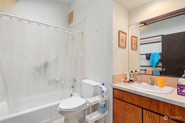 full bathroom with vanity, shower / bath combo with shower curtain, and toilet