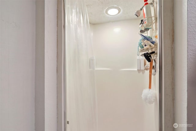 bathroom with a textured ceiling and walk in shower