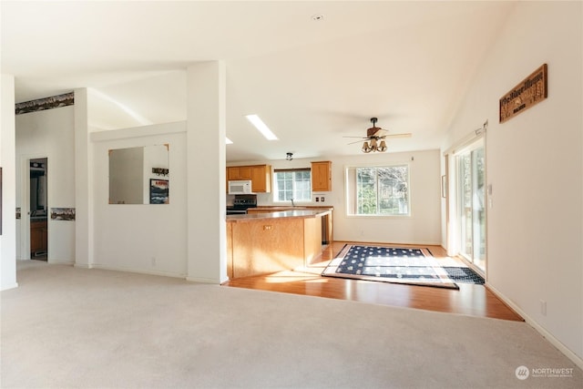 kitchen featuring vaulted ceiling, light colored carpet, electric range, and kitchen peninsula