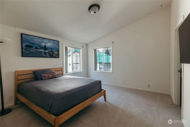 carpeted bedroom with lofted ceiling