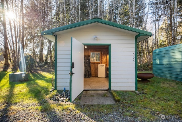 view of outbuilding with central AC and a lawn