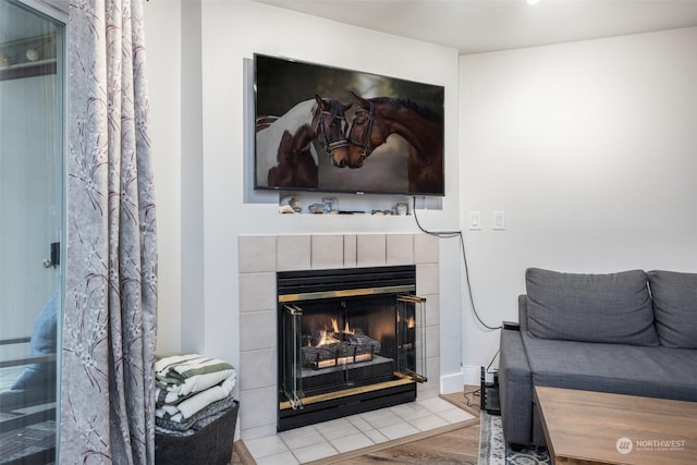 room details with a tiled fireplace and hardwood / wood-style flooring