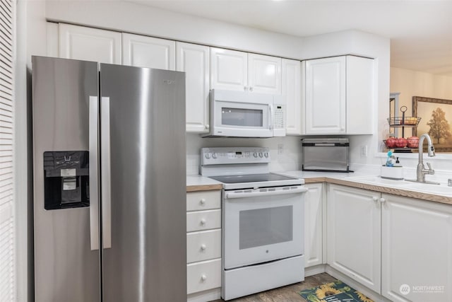 kitchen featuring white cabinetry, sink, white appliances, and light wood-type flooring