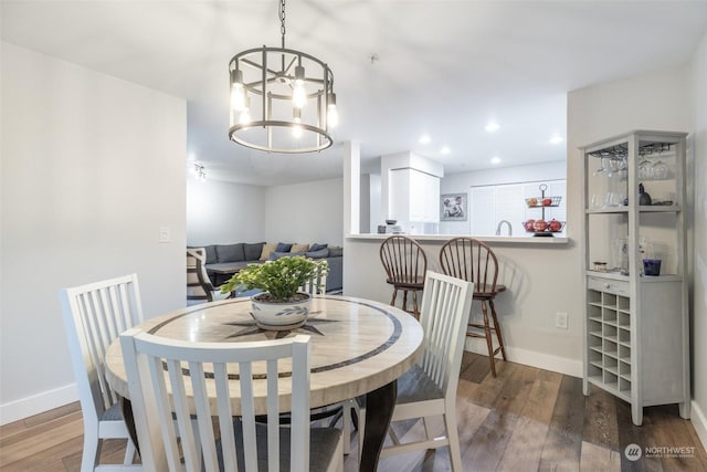 dining room with hardwood / wood-style floors and an inviting chandelier