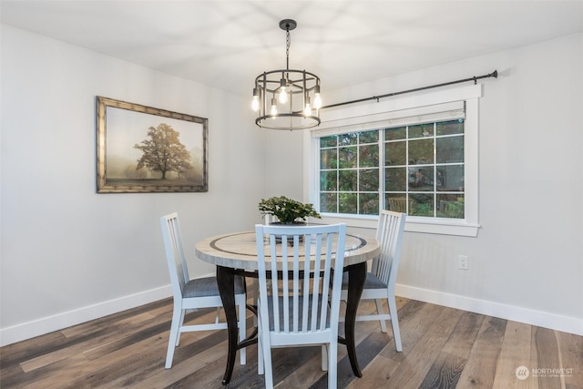 dining space with dark hardwood / wood-style floors and a chandelier