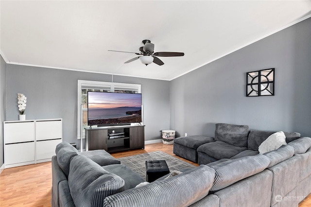 living room featuring hardwood / wood-style flooring, crown molding, and ceiling fan