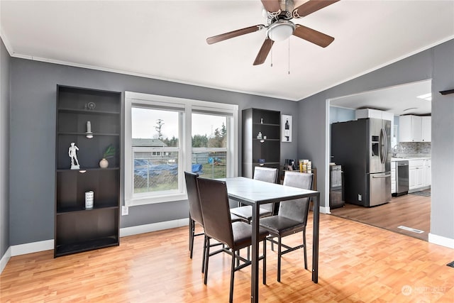 dining room featuring lofted ceiling, ornamental molding, ceiling fan, and light wood-type flooring