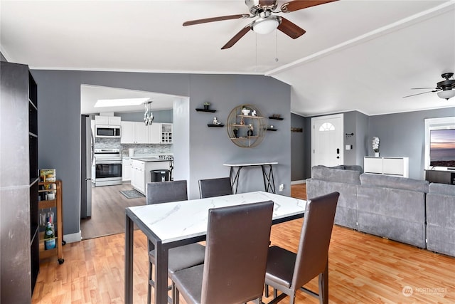 dining area featuring ceiling fan, lofted ceiling, and light hardwood / wood-style floors