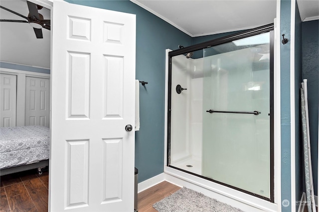 bathroom featuring wood-type flooring, ceiling fan, crown molding, and walk in shower