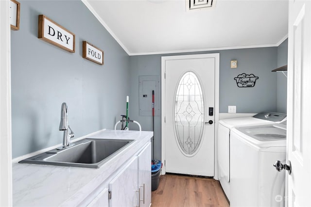 washroom featuring sink, ornamental molding, cabinets, and independent washer and dryer