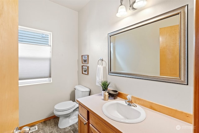 bathroom with vanity, wood-type flooring, and toilet