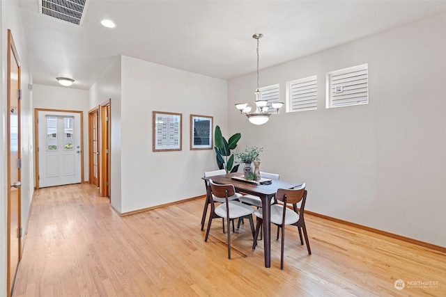 dining area featuring a chandelier and light wood-type flooring