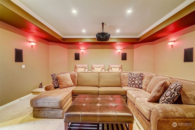 cinema room featuring a raised ceiling, ornamental molding, and carpet flooring