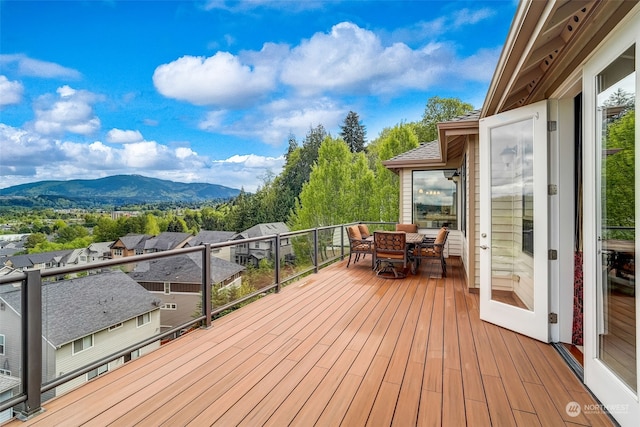 deck featuring a residential view, a mountain view, and outdoor dining area