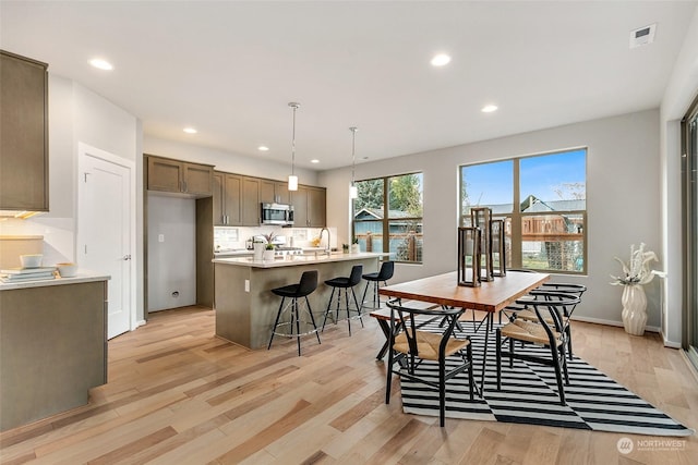 dining area with sink and light hardwood / wood-style floors