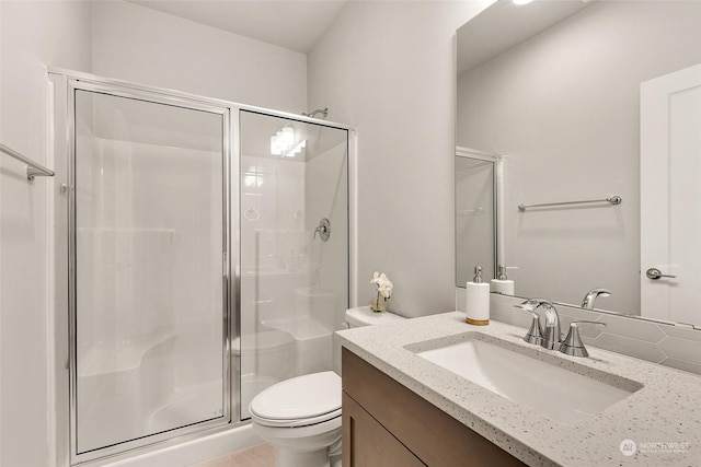 bathroom featuring an enclosed shower, vanity, and toilet