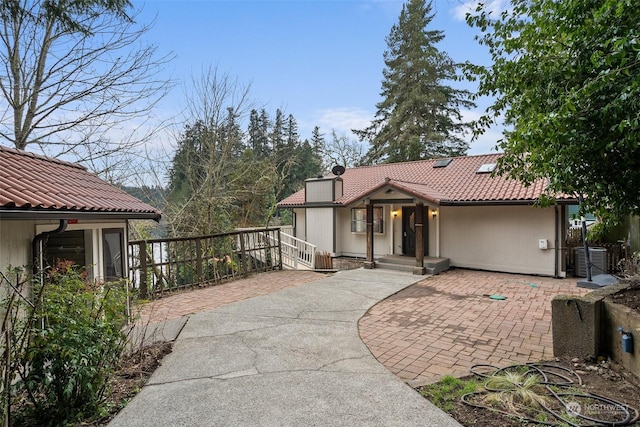 view of front of property with central AC and a patio