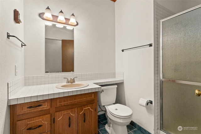 bathroom featuring vanity, a shower with shower door, tile patterned floors, and toilet