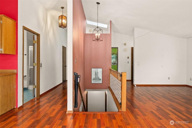 hallway with dark hardwood / wood-style flooring, a notable chandelier, and high vaulted ceiling