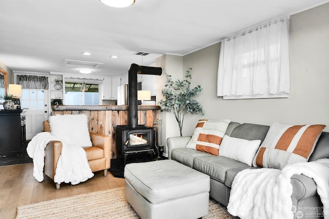 living room with hardwood / wood-style flooring and a wood stove