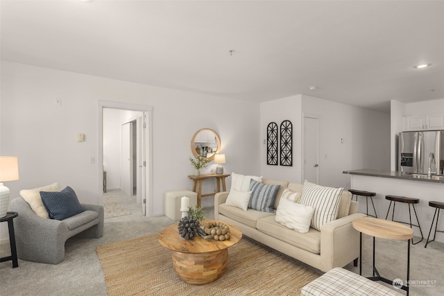 living room with light colored carpet and sink