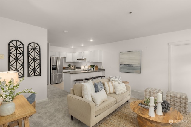 living room with sink and light carpet