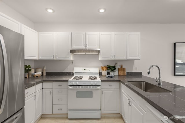 kitchen with white gas range, sink, stainless steel refrigerator, and white cabinets