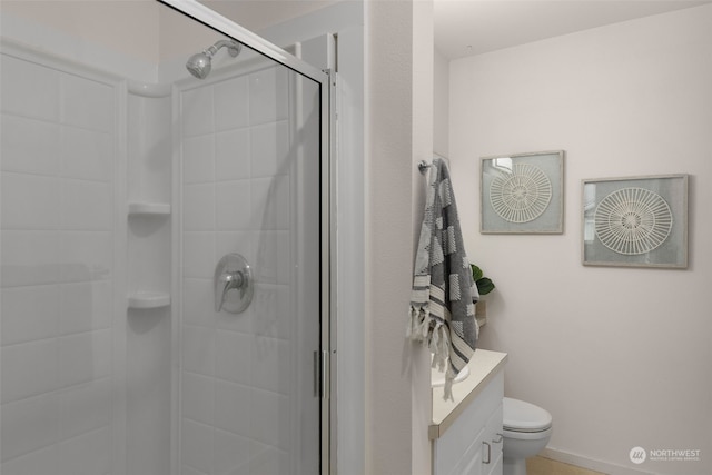 bathroom featuring vanity, toilet, and a shower with shower door