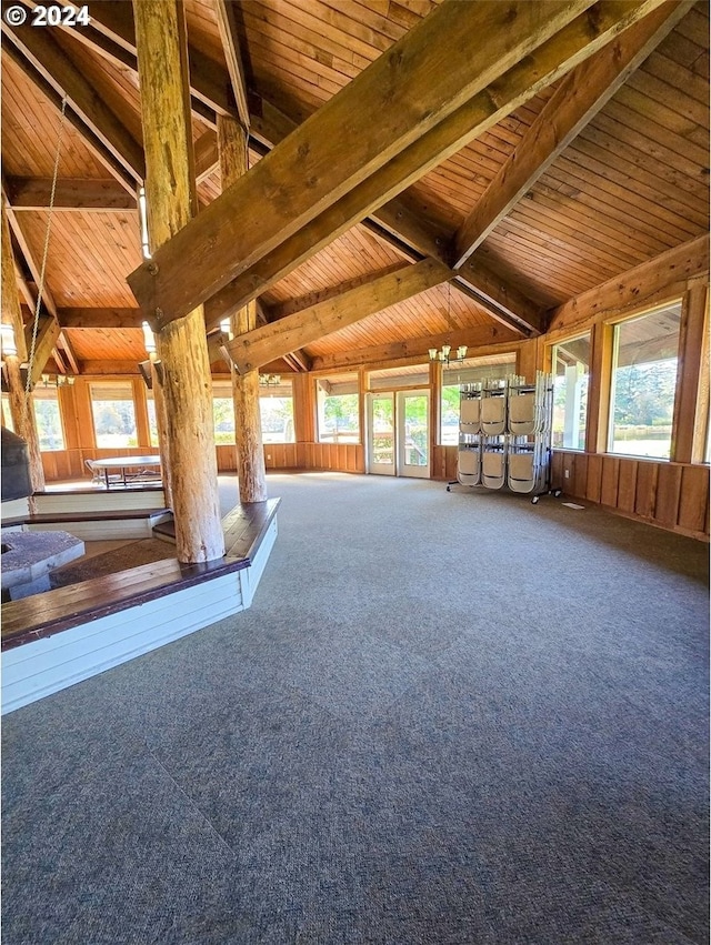 interior space with beam ceiling, a healthy amount of sunlight, carpet flooring, and wood ceiling