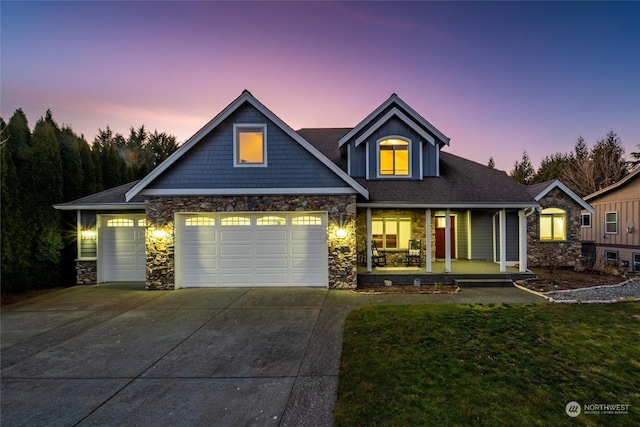 view of front of house with a porch, a garage, and a yard