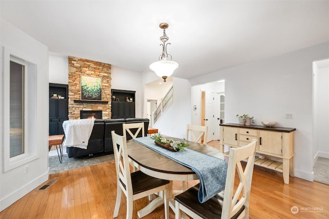 dining room featuring a fireplace and light wood-type flooring