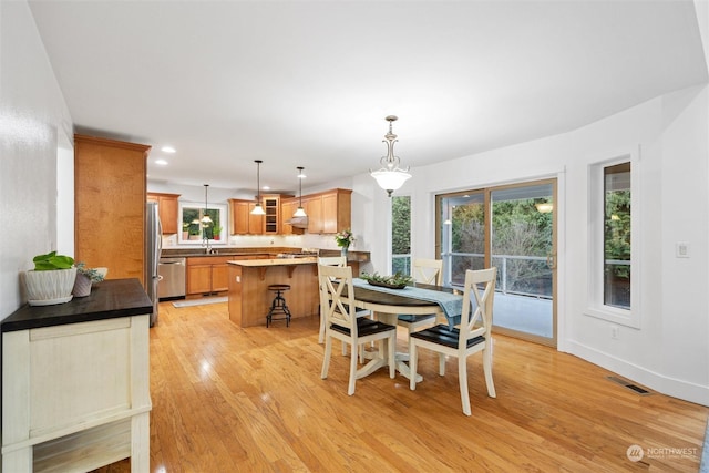 dining room with sink and light wood-type flooring